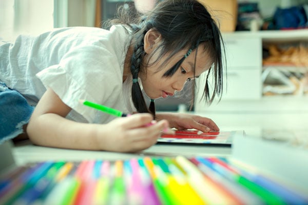 asian-children-playing-and-painting-color-pencil-on-paper-book-in-home-school